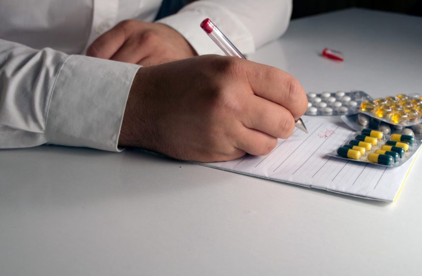 doctor writes prescription for medication management